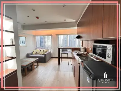 a kitchen and living room with a couch and a table at Panoramic View of City 1BR Loft Unit FREE WIFI & NETFLIX at Fort Victoria BGC in Manila
