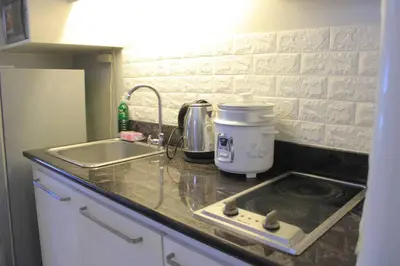 a kitchen counter top with a sink and a stove at A2J BGC Luxury 1BR Suite Near Burgos Circle & Mall in Manila