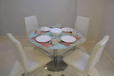 a table with white chairs and a blue table with plates at A2J BGC Luxury 1BR Suite Near Burgos Circle & Mall in Manila