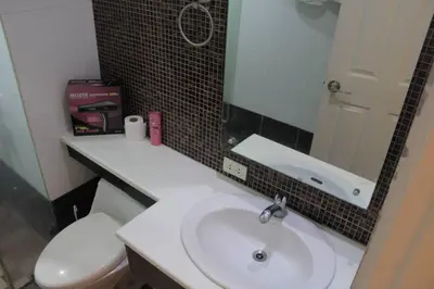 a bathroom with a white sink and a toilet at A2J BGC Luxury 1BR Suite Near Burgos Circle & Mall in Manila