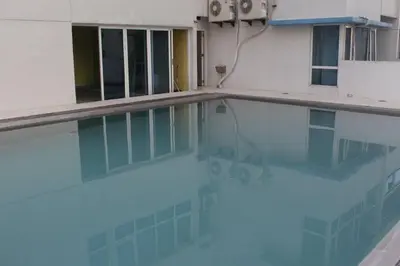 a swimming pool with blue water in a building at A2J BGC Luxury 1BR Suite Near Burgos Circle & Mall in Manila