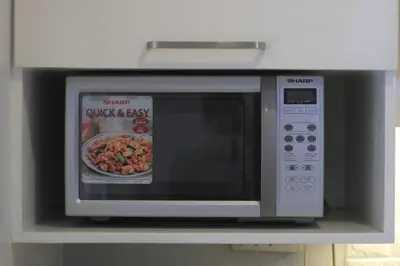 a microwave oven with a picture of a bowl of food at A2J BGC Luxury 1BR Suite Near Burgos Circle & Mall in Manila