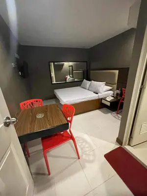 a small room with a bed and a table and chairs at Hotel Sogo Edsa Cubao in Manila