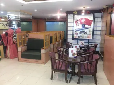 a restaurant with a table and chairs and a counter at Hotel Sogo Edsa Cubao in Manila