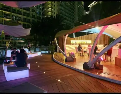 a group of people sitting on a deck at night at Azure Urban Resort in Manila