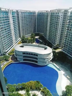 a large building with a large pool in front of tall buildings at Azure Urban Resort in Manila