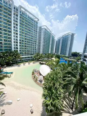 a resort with a pool and palm trees and buildings at Azure Urban Resort in Manila