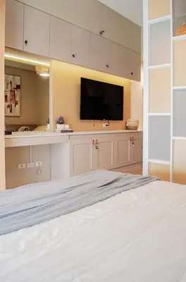 a bedroom with a white bed and a flat screen tv at Cozy and Classy Studio Across Airport Terminal 3 in Manila