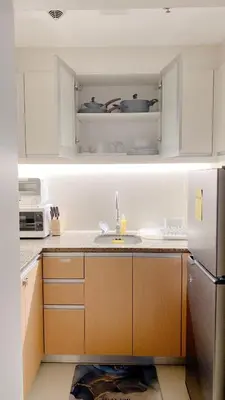 a kitchen with a sink and a white refrigerator at Cozy and Classy Studio Across Airport Terminal 3 in Manila