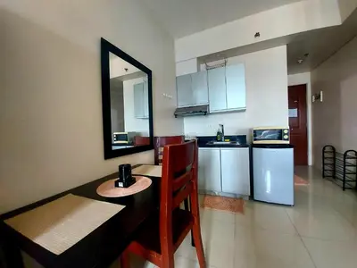 a kitchen with a table and a mirror on the wall at Great Place at Beacon Tower Makati in Manila