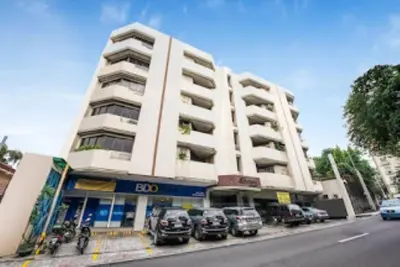 a large white building with cars parked in front of it at Benson Hotel San Juan CIty in Manila
