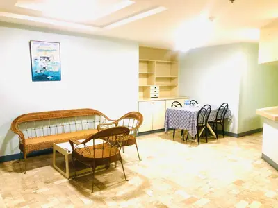 a room with chairs and a table and a kitchen at Benson Hotel San Juan CIty in Manila
