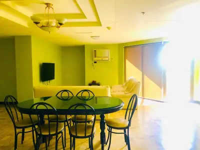 a dining room with a green table and chairs at Benson Hotel San Juan CIty in Manila