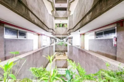 a hallway of a building with stairs and plants at Benson Hotel San Juan CIty in Manila