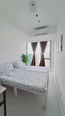 a white bed in a room with a window at S-A-F-E Haven Resort Staycation in Manila
