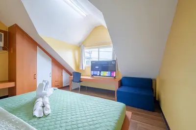 a bedroom with a bed and a blue couch at Casa Heradurra Uno/Dos in Manila