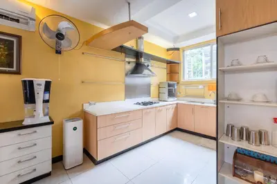 a kitchen with yellow walls and wooden cabinets at Casa Heradurra Uno/Dos in Manila