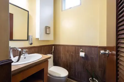 a bathroom with a sink and a toilet and a mirror at Casa Heradurra Uno/Dos in Manila