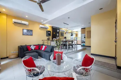 a living room with a glass table and red chairs at Casa Heradurra Uno/Dos in Manila