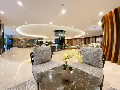 a lobby with two chairs and a table with flowers on it at Will’s Place @ Shore2 Residences Mall of Asia in Manila