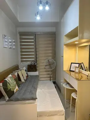 a room with a bed with a fan and a desk at Mel and Rose Place in S Residences Tower 1 MOA in Manila