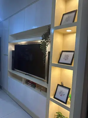a entertainment center with a flat screen tv in a room at Mel and Rose Place in S Residences Tower 1 MOA in Manila
