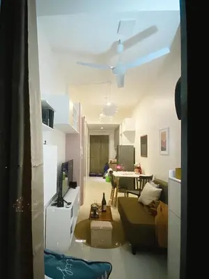 a living room with a couch and a ceiling fan at Fame Residences Tower-1 Unit 3207 in Mandaluyong 1 Br w Balcony City view in Manila