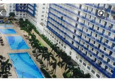 an overhead view of a large building with palm trees and pools at Sea Residences Prestige in Manila