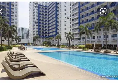 a large swimming pool in a city with tall buildings at Sea Residences Prestige in Manila