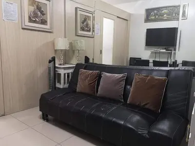 a black leather couch in a living room at Sea Residences Prestige in Manila