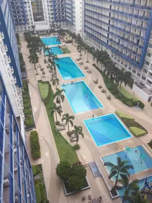 an aerial view of three swimming pools in a city at Easy Stay Sea Residences in Manila