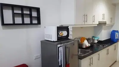 a kitchen with a microwave on top of a refrigerator at Easy Stay Sea Residences in Manila