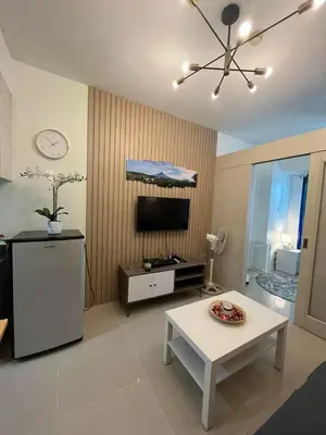 a living room with a table and a tv at Easy Stay Sea Residences in Manila