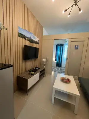 a living room with a table and a tv in it at Easy Stay Sea Residences in Manila