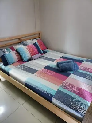 a bed with colorful blankets and pillows on it at Easy Stay Sea Residences in Manila