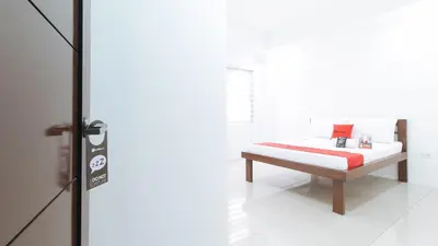 a bedroom with a bed with a red pillow at RedDoorz Plus at DBuilders Poblacion BGC in Manila