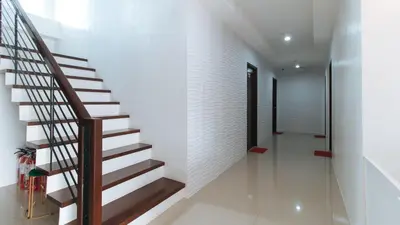 a staircase in a house with white walls at RedDoorz Plus at DBuilders Poblacion BGC in Manila