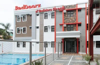 a building with a swimming pool in front of it at RedDoorz Plus at DBuilders Poblacion BGC in Manila
