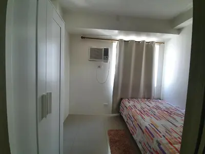 a small bedroom with a bed and a window at Shore 1 Residences,MOA Complex - One Bedroom Apartment in Manila