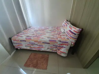 a small bed in a corner of a room at Shore 1 Residences,MOA Complex - One Bedroom Apartment in Manila
