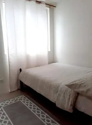 a bedroom with a bed with a window and a rug at Shore 1 Residences,MOA Complex - One Bedroom Apartment in Manila