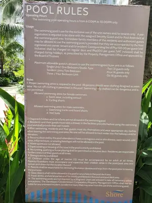 a sign in front of some plants at Shore 1 Residences,MOA Complex - One Bedroom Apartment in Manila