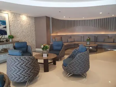 a lobby with blue chairs and a couch and tables at Shore 1 Residences,MOA Complex - One Bedroom Apartment in Manila