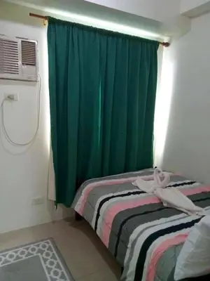 a bedroom with a bed and a green curtain at Shore 1 Residences,MOA Complex - One Bedroom Apartment in Manila