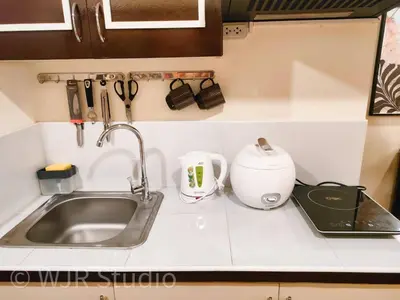 a kitchen counter with a sink and a mixer at Queen Bed Deluxe- Contemporary Style in Manila
