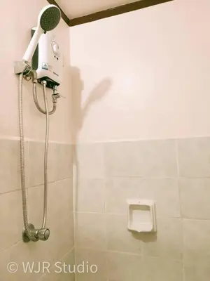 a shower in a bathroom with a hair dryer at Queen Bed Deluxe- Contemporary Style in Manila