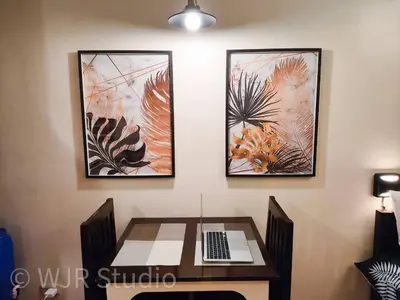 a table with a computer and three pictures on the wall at Queen Bed Deluxe- Contemporary Style in Manila