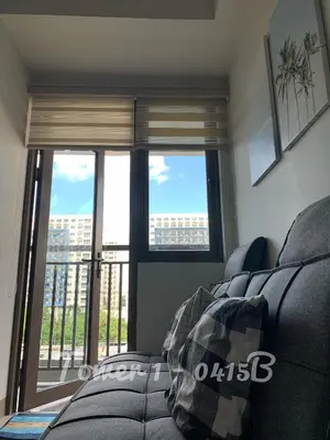 a living room with a couch and a large window at SMDC S Residences MiCasa, MOA area in Manila