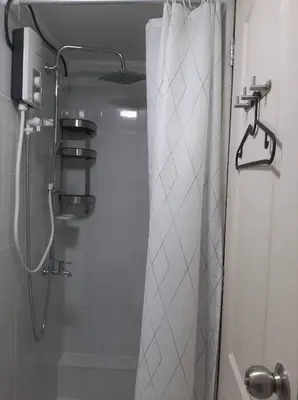 a shower with a shower curtain in a bathroom at Lovely 2 BR Condo with FREE Secured Parking in Manila