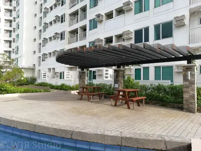 two picnic tables under a canopy in front of a building at Choco Condotel- Anuva Prime 2 Cozy & Stylish Place in the Metro in Manila